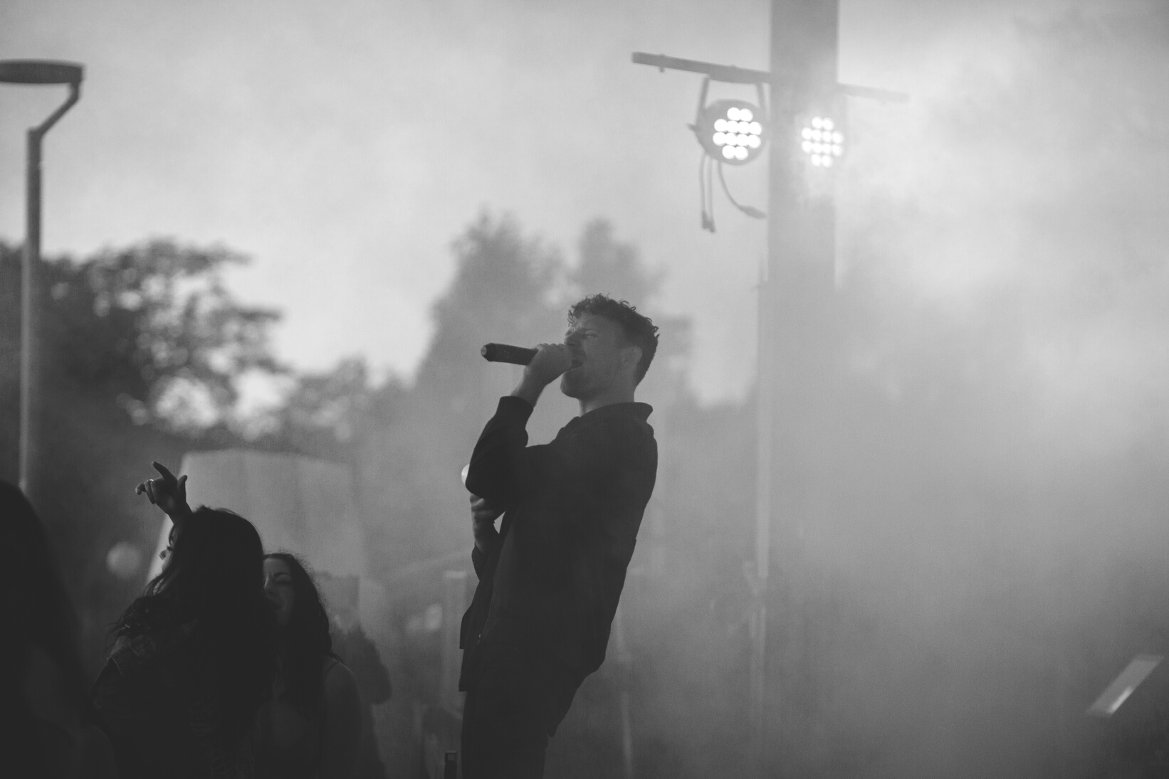 Man in Black Jacket Singing on Stage